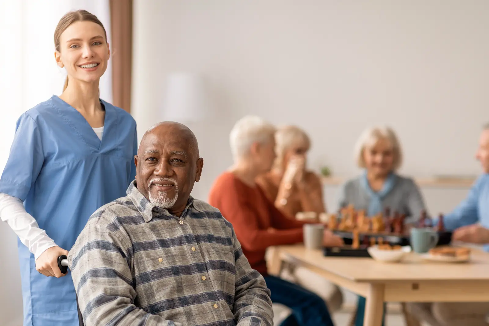 Care worker with residents in a care facility lounge