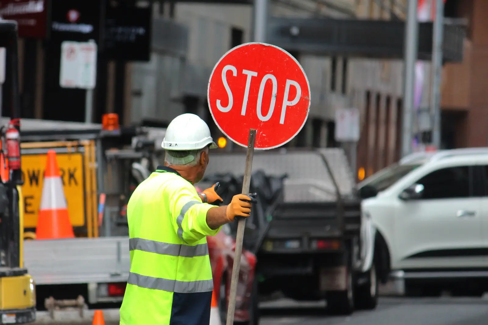 Traffic management crew in hi-vis setting out cones and barriers on a road